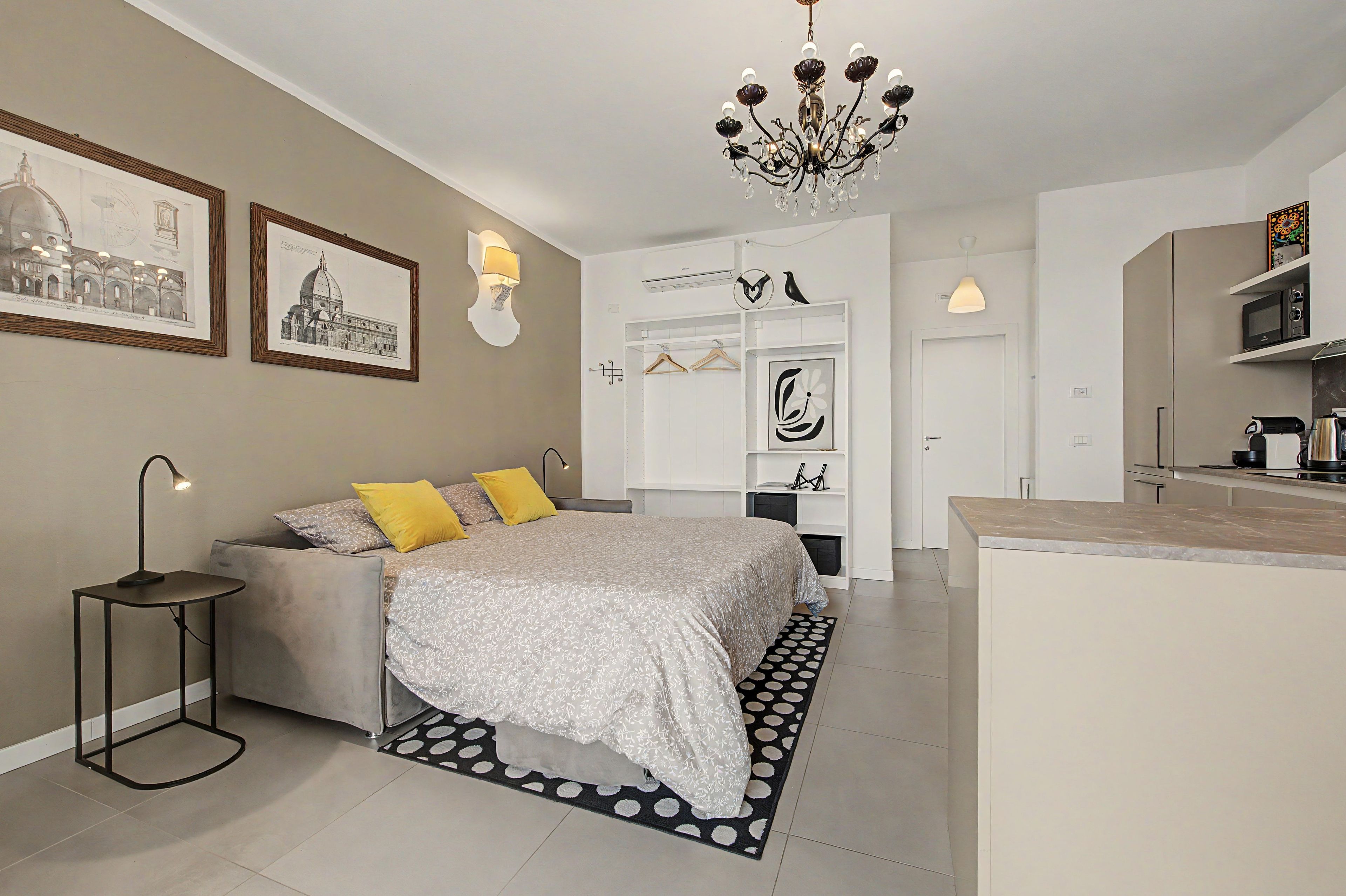 Une chambre à coucher moderne avec un lit, une table de chevet, une lampe et un lustre.