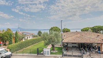 A coastal property with a tiled roof, a fenced garden, and a view of the sea.