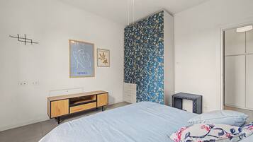 Ein Schlafzimmer mit einem Bett, einem Schminktisch, einem Kleiderschrank und einem kleinen Tisch.