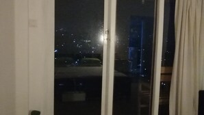 A room with a large window, a bed, a potted plant, and a curtain. - Glenview Hotel and homestay (Kandy)