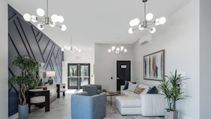 A modern lobby with a sofa, chairs, a coffee table, and a potted plant.