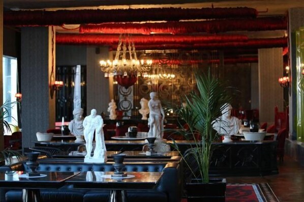A lobby with a chandelier, statues, and a red accent wall. - Selectum Luxury Resort Belek (Serik)
