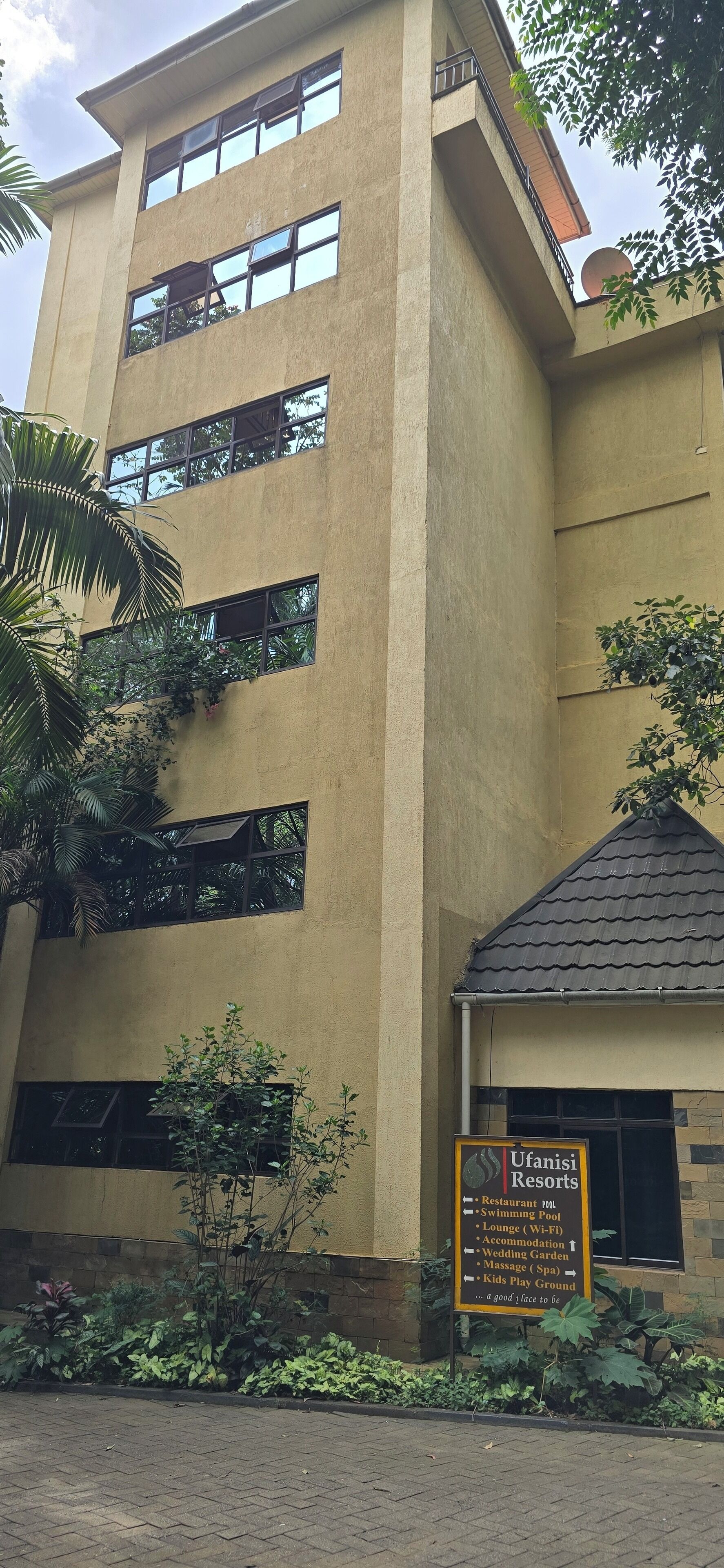 Un edificio con varias ventanas y un cartel que indica Ufanisi Resorts.