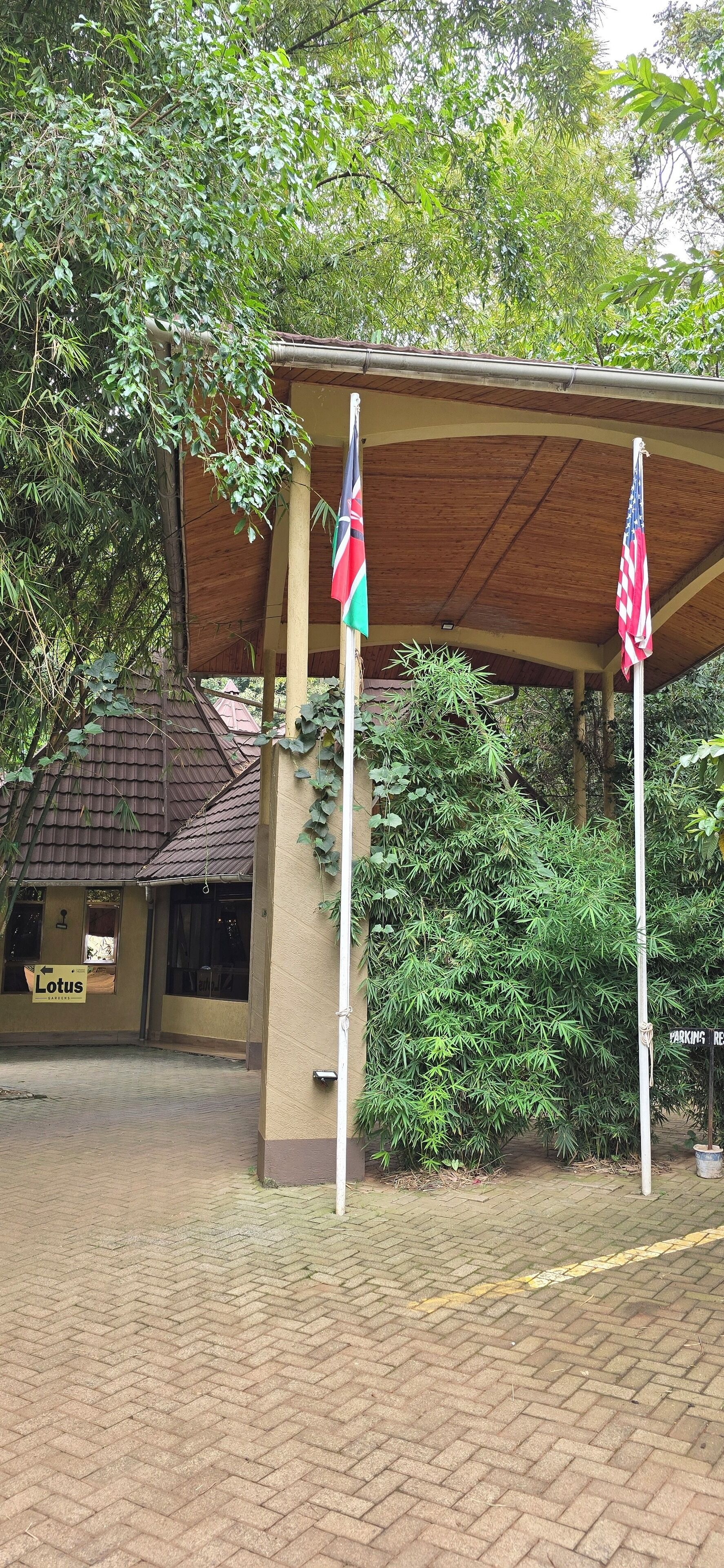 Un bâtiment doté d’une entrée couverte, de drapeaux et d’une enseigne indiquant « Lotus ».