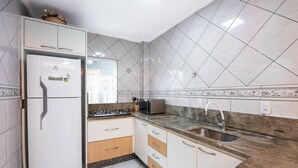 A kitchen with white cabinets, a built-in refrigerator, a microwave, and a sink. - Apts in Condominium 40 Meters From Bombinhas Beach - Bdss (Bombinhas)