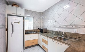 A kitchen with white cabinets, a built-in refrigerator, a microwave, and a sink. - Apts in Condominium 40 Meters From Bombinhas Beach - Bdss (Bombinhas)