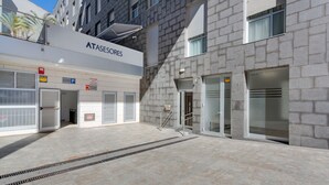 Un edificio moderno con un letrero que dice 'ATASESORES' y un acceso cubierto.