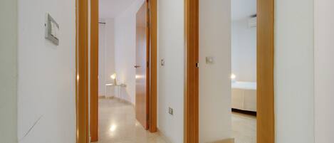 Un pasillo con una puerta de madera que da a un dormitorio.