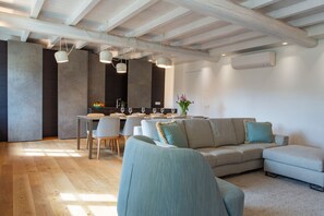 A modern living room with a sofa, dining table, and chairs. - On My Way Loft-Central Rooftop Apt with AC/Terrace (Como)