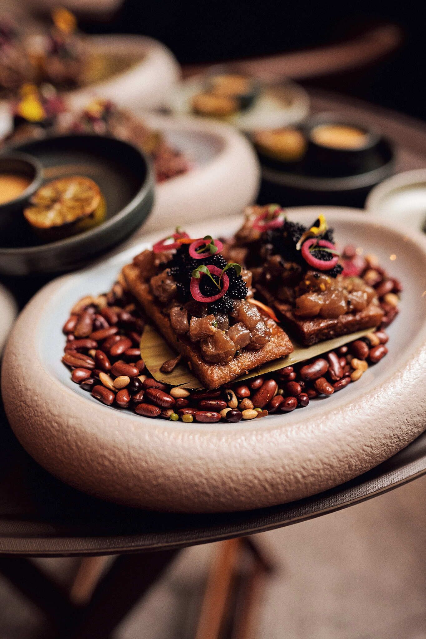 A plate of food with beans and a decorative garnish.