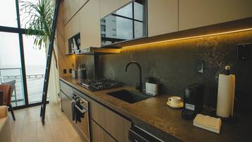 Signature studio suite, uitzicht op de binnenplaats | Privékeuken | Een koelkast, een microgolfoven, een oven, een kookplaat