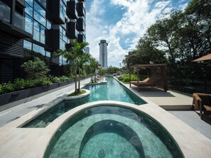 Une piscine extérieure moderne, offrant une vue dégagée sur un grand immeuble en arrière-plan.