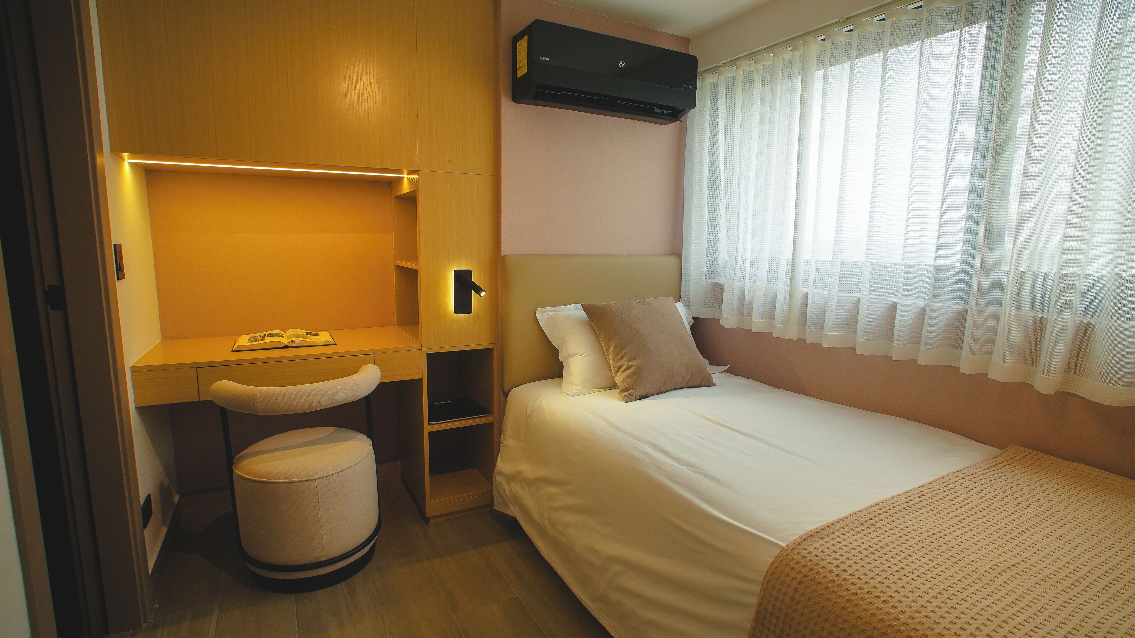 A compact bedroom with a bed, a desk, and a chair.