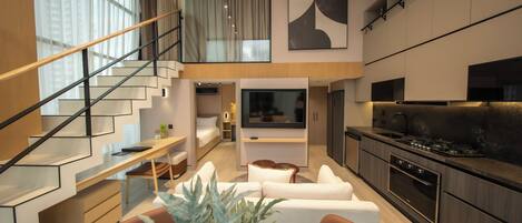 A modern apartment with a living area, kitchen, and a staircase leading to an upper level.