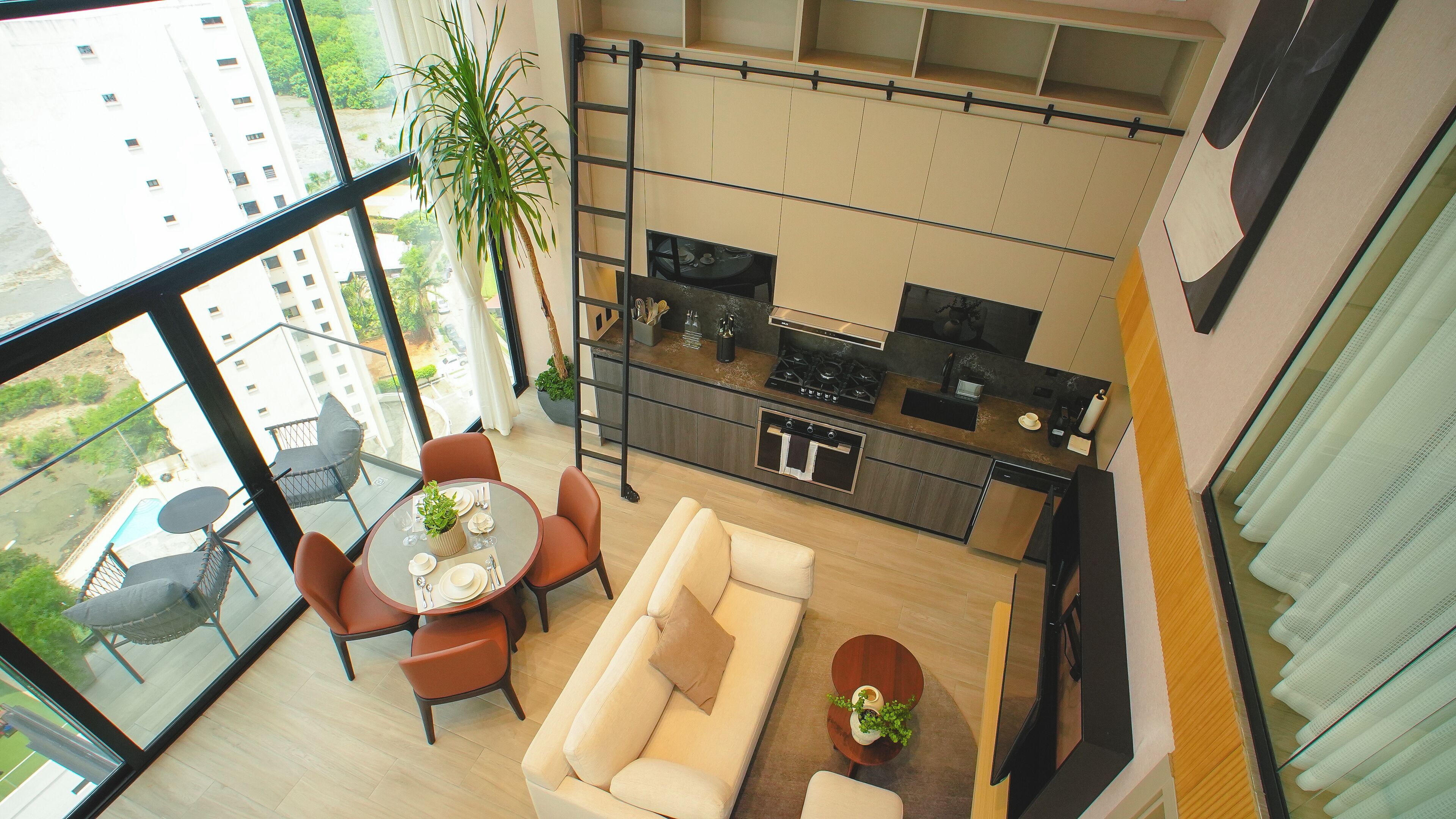 A modern apartment with a kitchen, dining area, and a balcony with a view of the city.