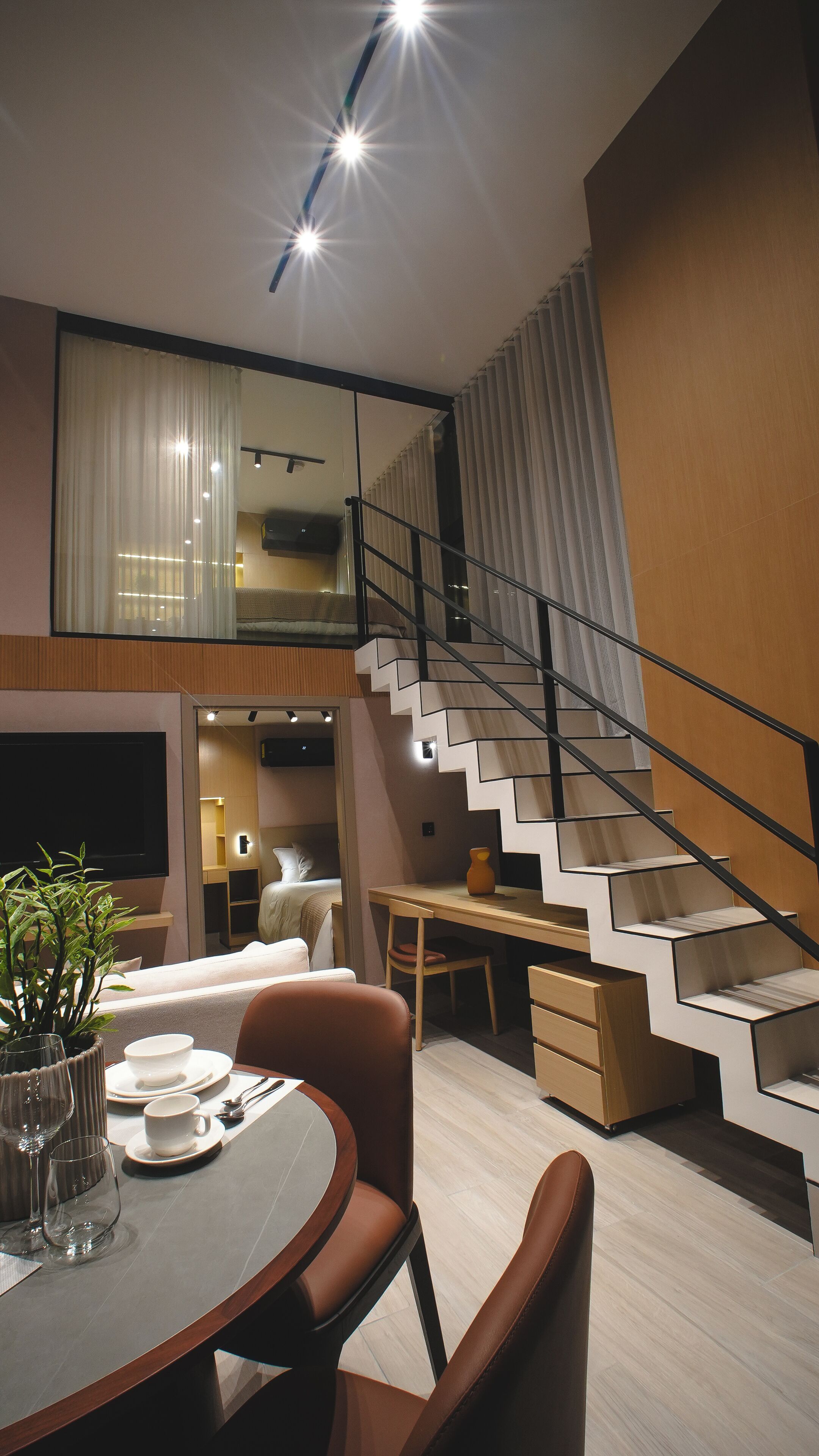 Un intérieur moderne comprenant un escalier, un coin repas et un espace de vie.
