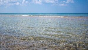 A clear view of a beach with calm waters and a clear sky. - Grand Beach 4BR Pool House with Private Pool, Golf Cart & Fireplace (New Buffalo)