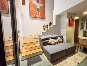 A modern interior with a staircase leading to a sofa area.