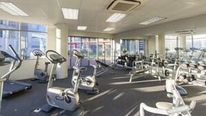 Una palestra con tapis roulant, ellittiche e pesi liberi.