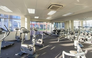 Una palestra con cyclette, tapis roulant e pesi.