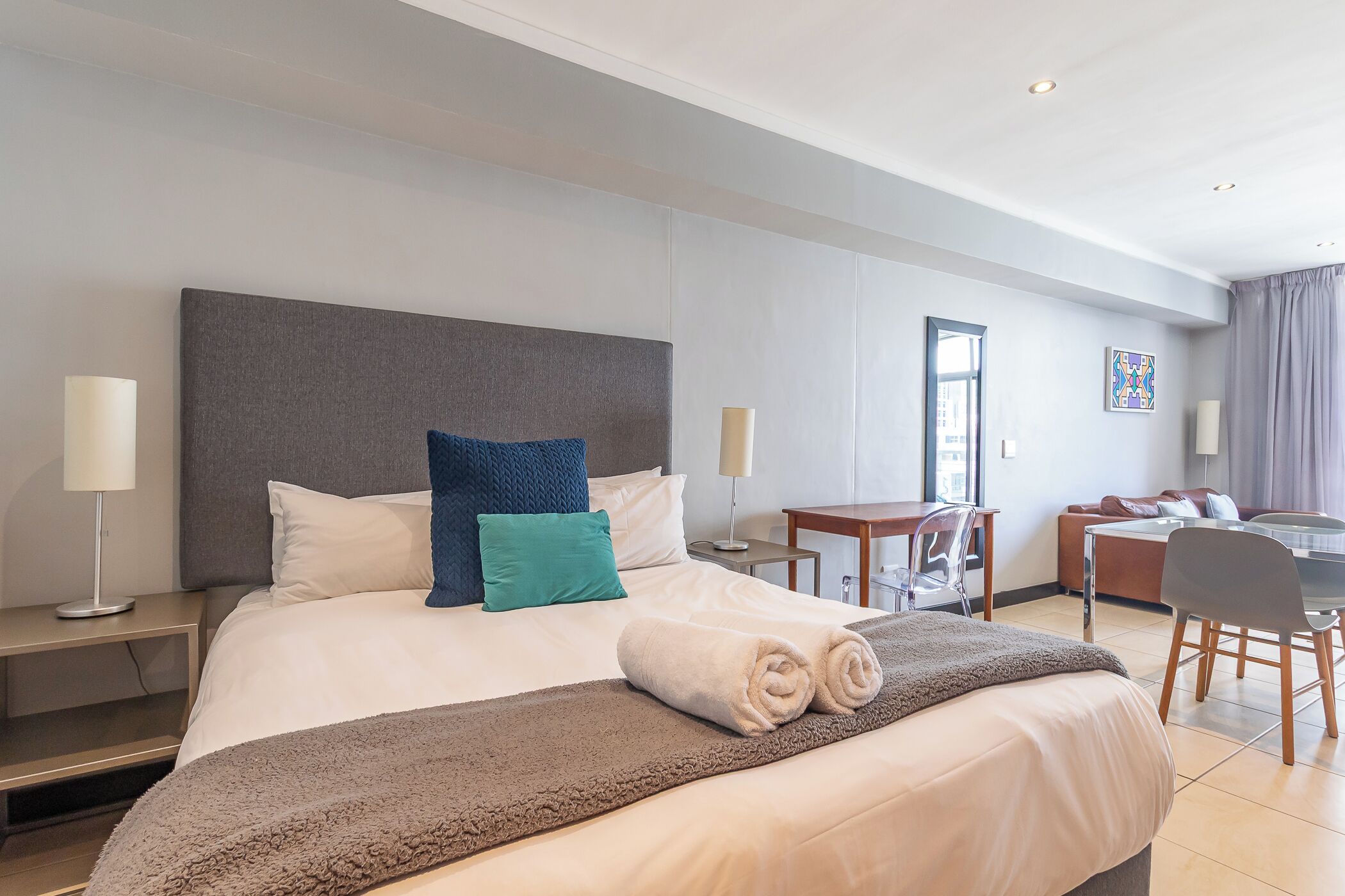 Une chambre d’hôtel avec un grand lit, un bureau, une chaise et un canapé.