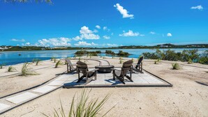 Een terras aan het strand met buitenmeubels en uitzicht op de oceaan.