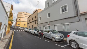 Una stretta via fiancheggiata da auto parcheggiate e palazzi.