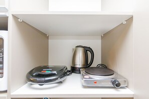 A kitchen with a coffee maker, a kettle, and a rice cooker on a white countertop. - Studio com Sacada All You Need ALL0305 (Curitiba)