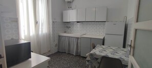 Kjøleskap, mikrobølgeovn, kokeplater og høy barnestol