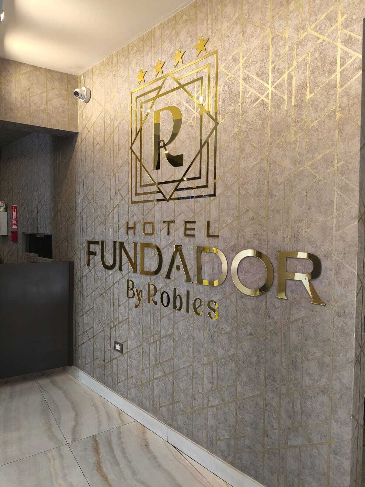 A hotel sign with a geometric design and the name 'HOTEL FUNDADOR By Robles'.