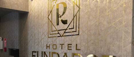A hotel sign with a geometric design and the name 'HOTEL FUNDADOR By Robles'.