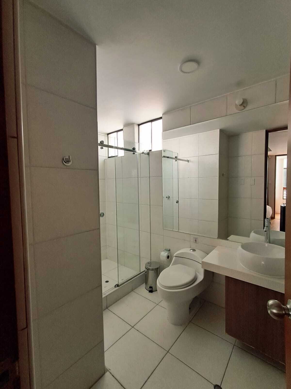 A modern bathroom with a toilet, bidet, and a glass-enclosed shower.