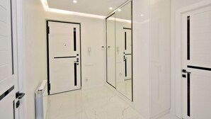 A hallway with white doors, a large mirror, and recessed ceiling lighting. - Apartment by Luxe Group SA222 (Yerevan)
