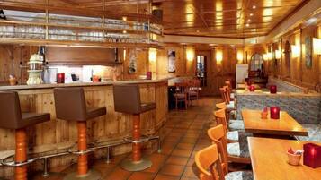 A bar area with stools, tables, and a counter.
