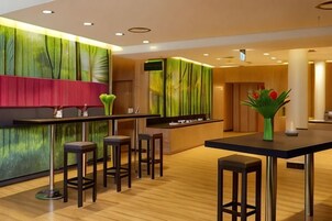 A modern bar area with stools, a counter, and a decorative vase.