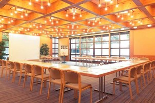 Un salón de conferencias con una mesa larga, sillas y una pizarra.