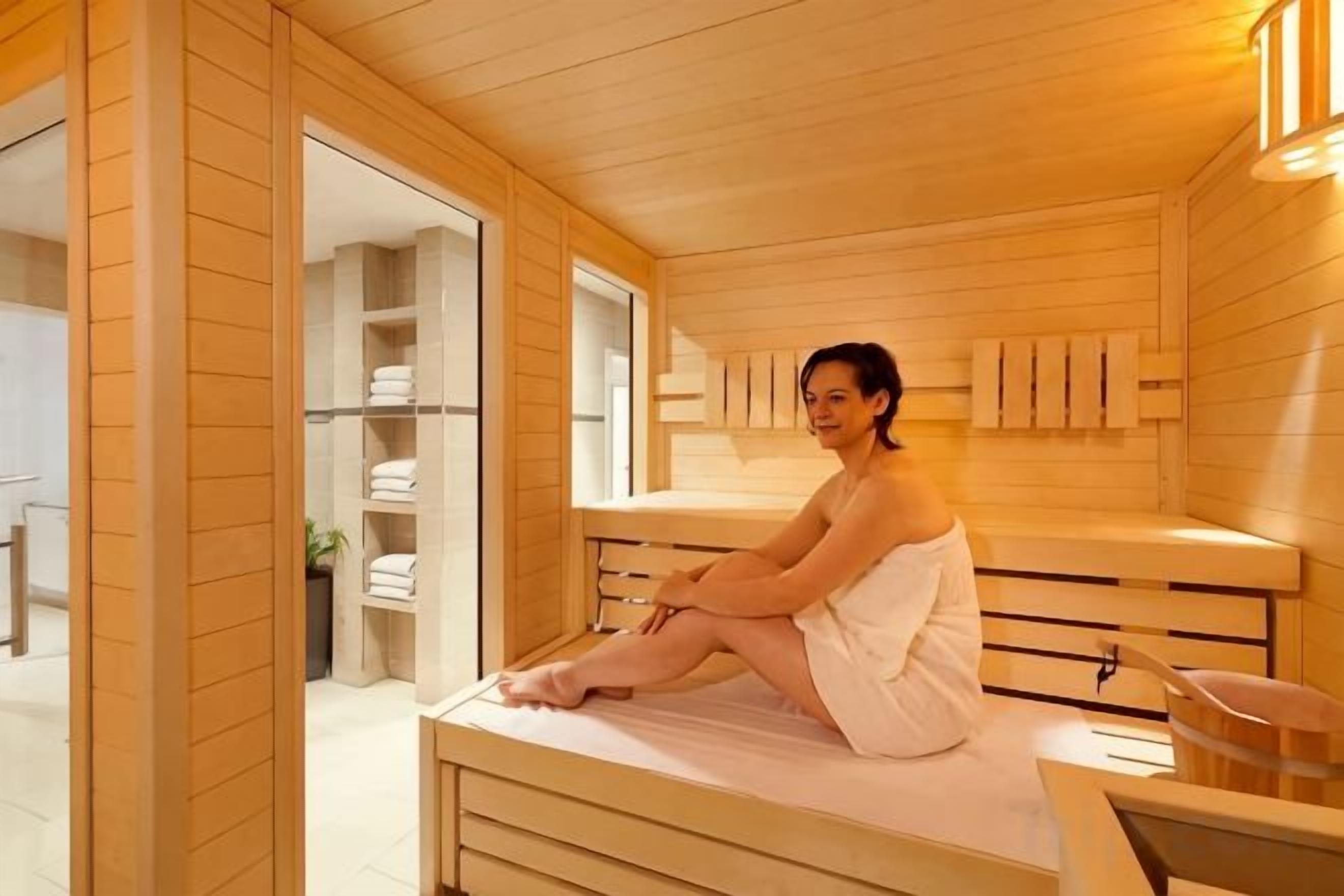 Ein Holzsaunaraum mit einer Bank, einem Handtuchhalter und einem Fenster.