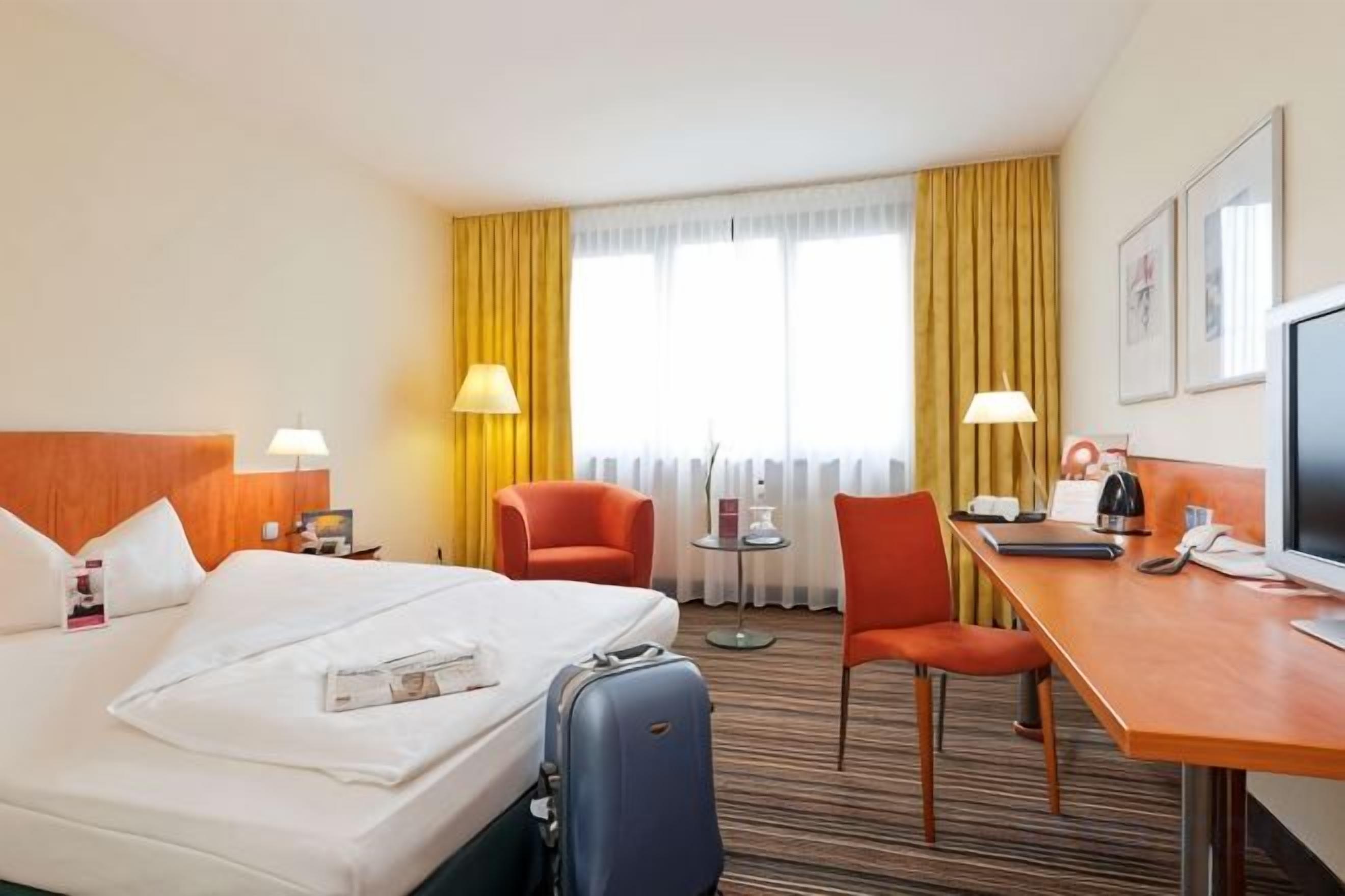 Une chambre d’hôtel équipée d’un lit, d’un bureau, d’une chaise et d’un téléviseur.