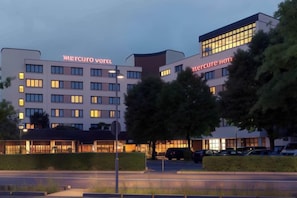 A hotel with multiple floors, a parking lot, and a well-lit entrance. - Mercure Hotel Offenburg am Messeplatz (Offenburg)