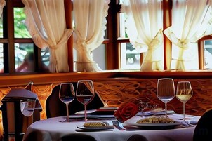 A dining table with wine glasses, plates of food, and a candle.