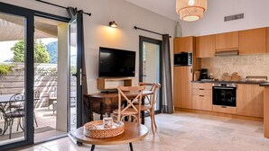 Une cuisine moderne avec des meubles en bois, un téléviseur à écran plat et un coin repas comprenant une table et des chaises.