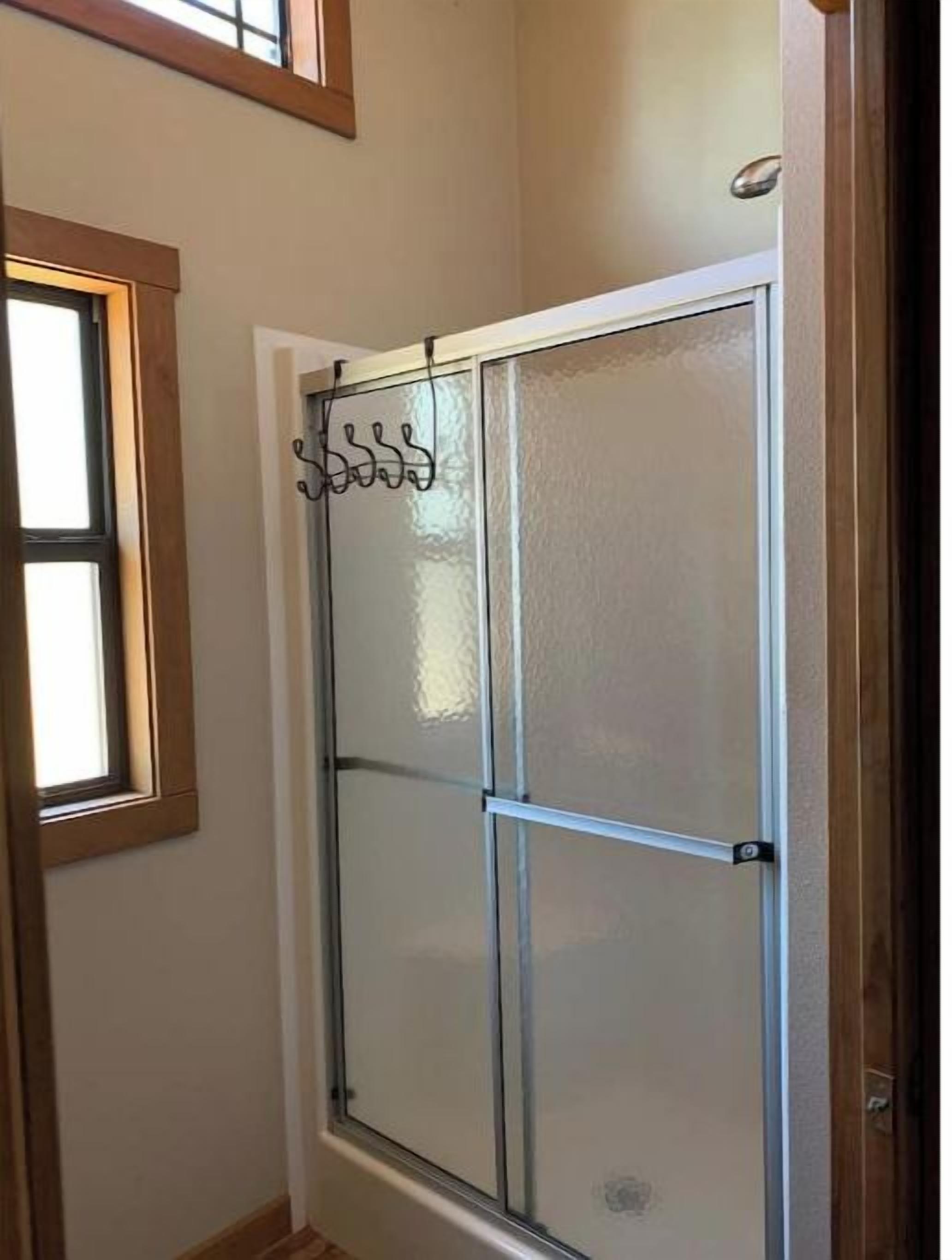 Una habitación con puerta de vidrio, ventana y marco de madera.