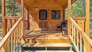 A wooden cabin with a porch, a door, and a window. - Barnwell Mountain Cabins #6 (Gilmer)