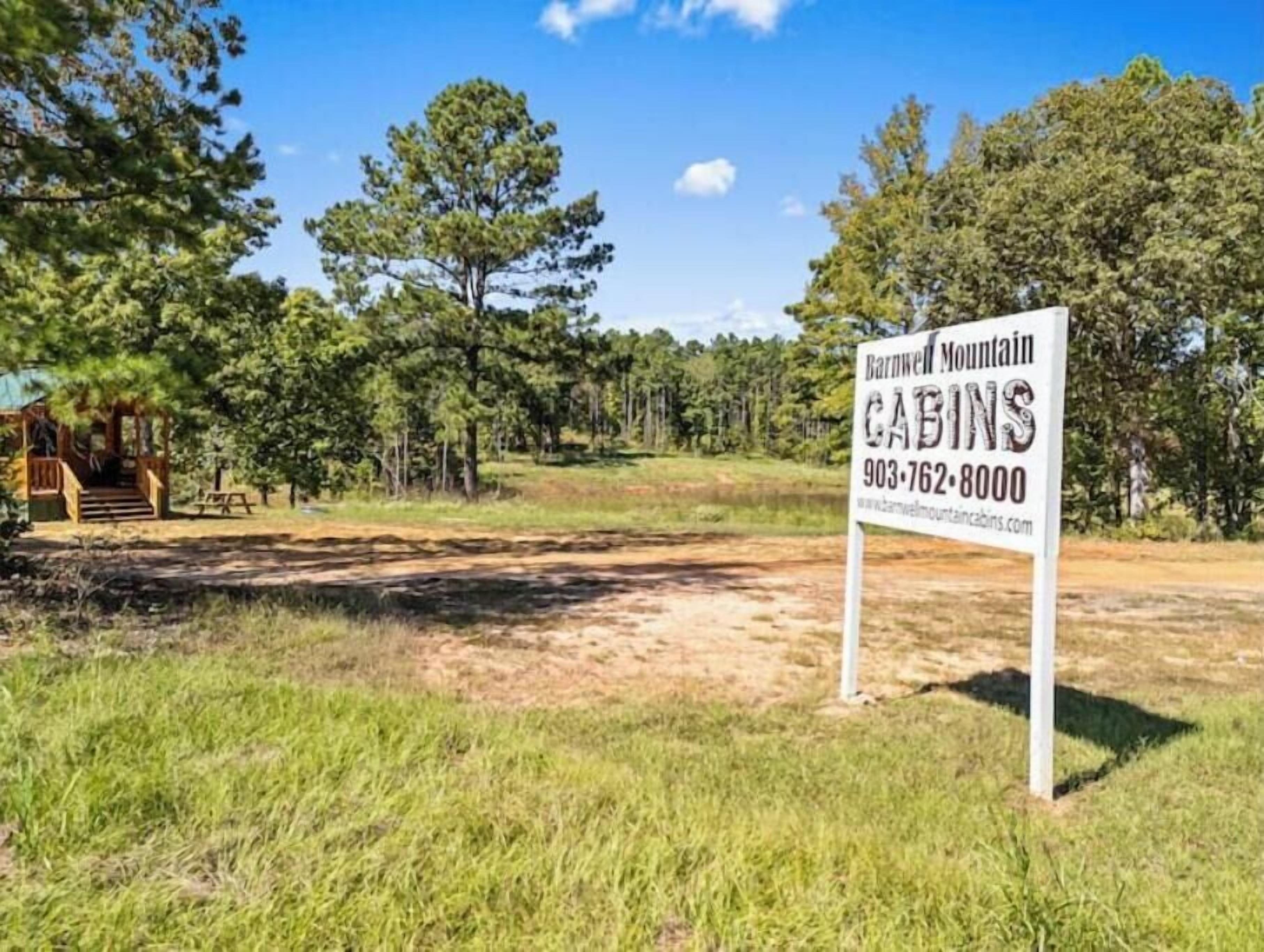 A sign for Barnwell Mountain Cabins with a contact number and website.