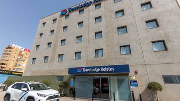 Un hotel Travelodge con fachada moderna, múltiples ventanas y una entrada visible.