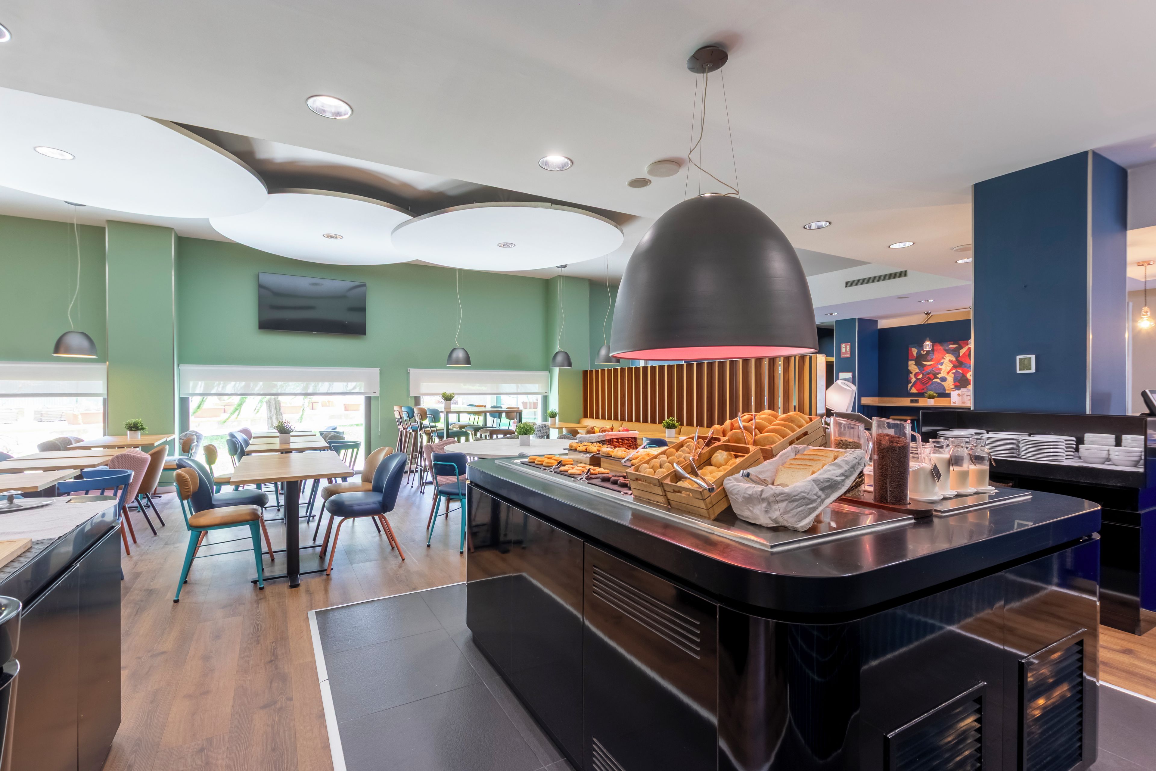 A modern restaurant with a buffet counter, wooden paneling, and a variety of food items.