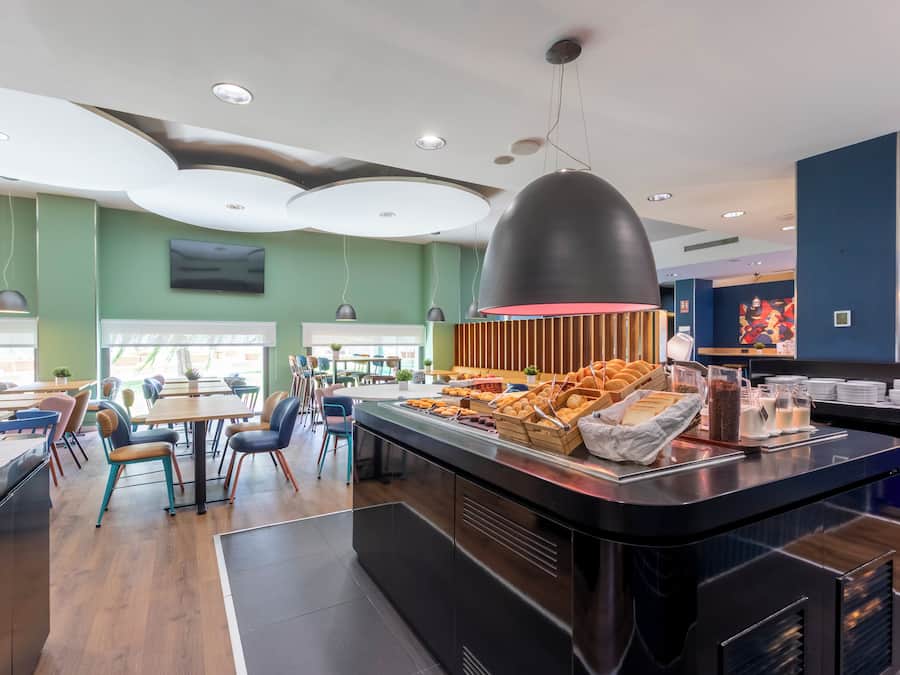 Een modern restaurant met een buffet, houten lambrisering en diverse gerechten.