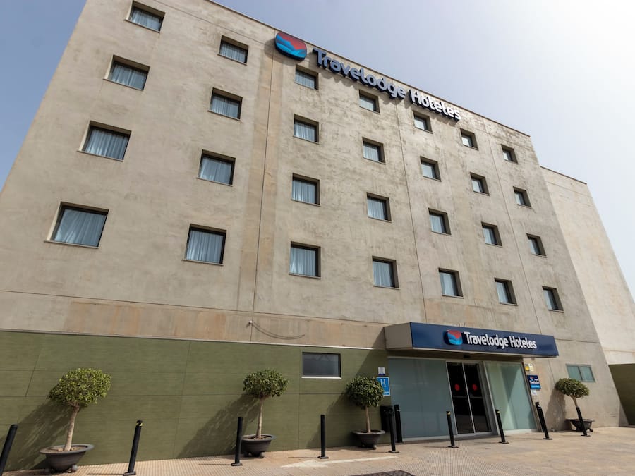 A Travelodge Hotel building with a flat facade, multiple windows, and a sign above the entrance.