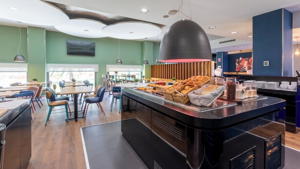 Un restaurant moderne doté d’un buffet, de lambris en bois et proposant une grande variété de plats.