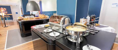 A buffet setup with various food items and utensils.